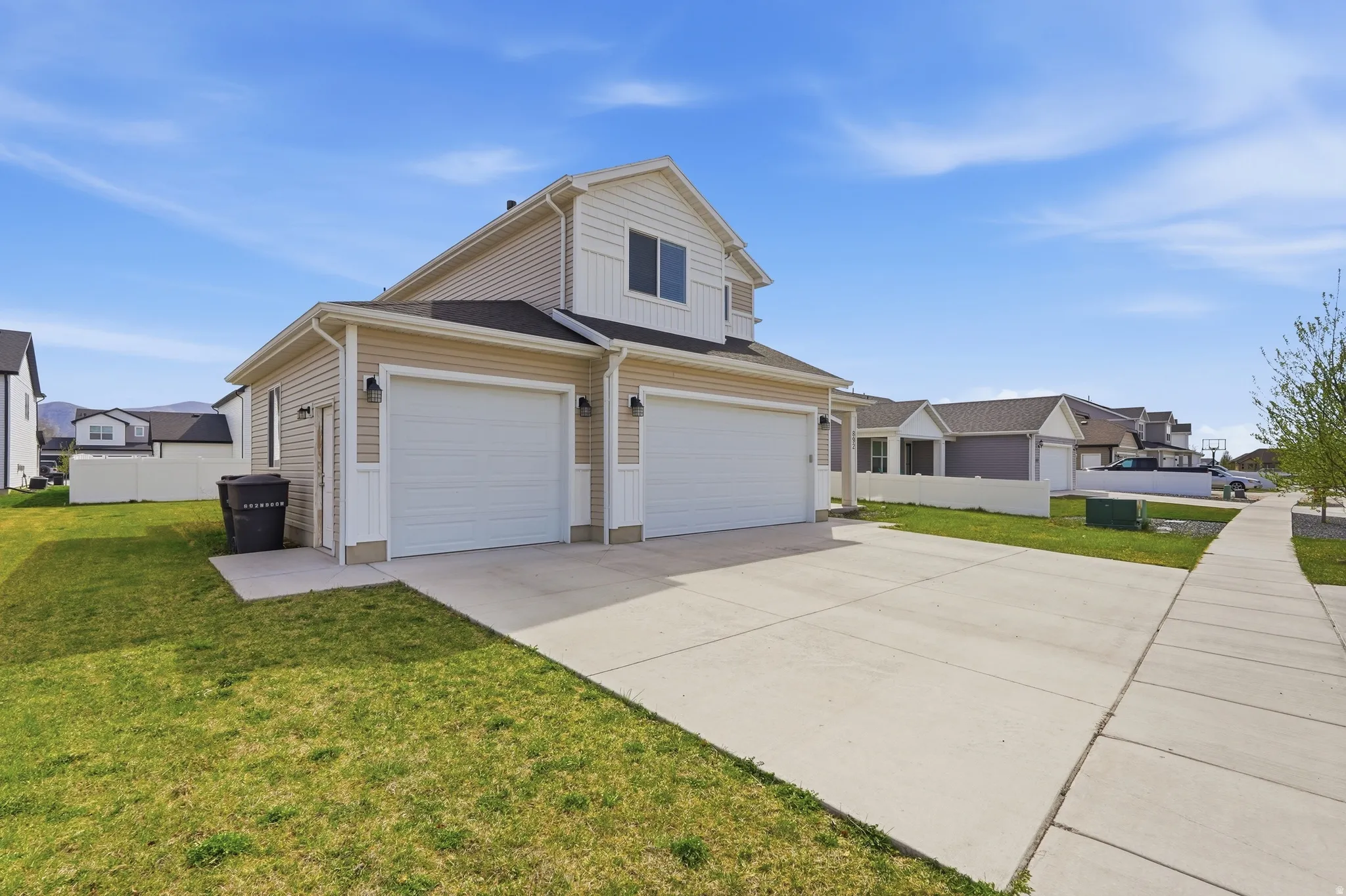 View of front of house featuring driveway, a front lawn, and a residential view