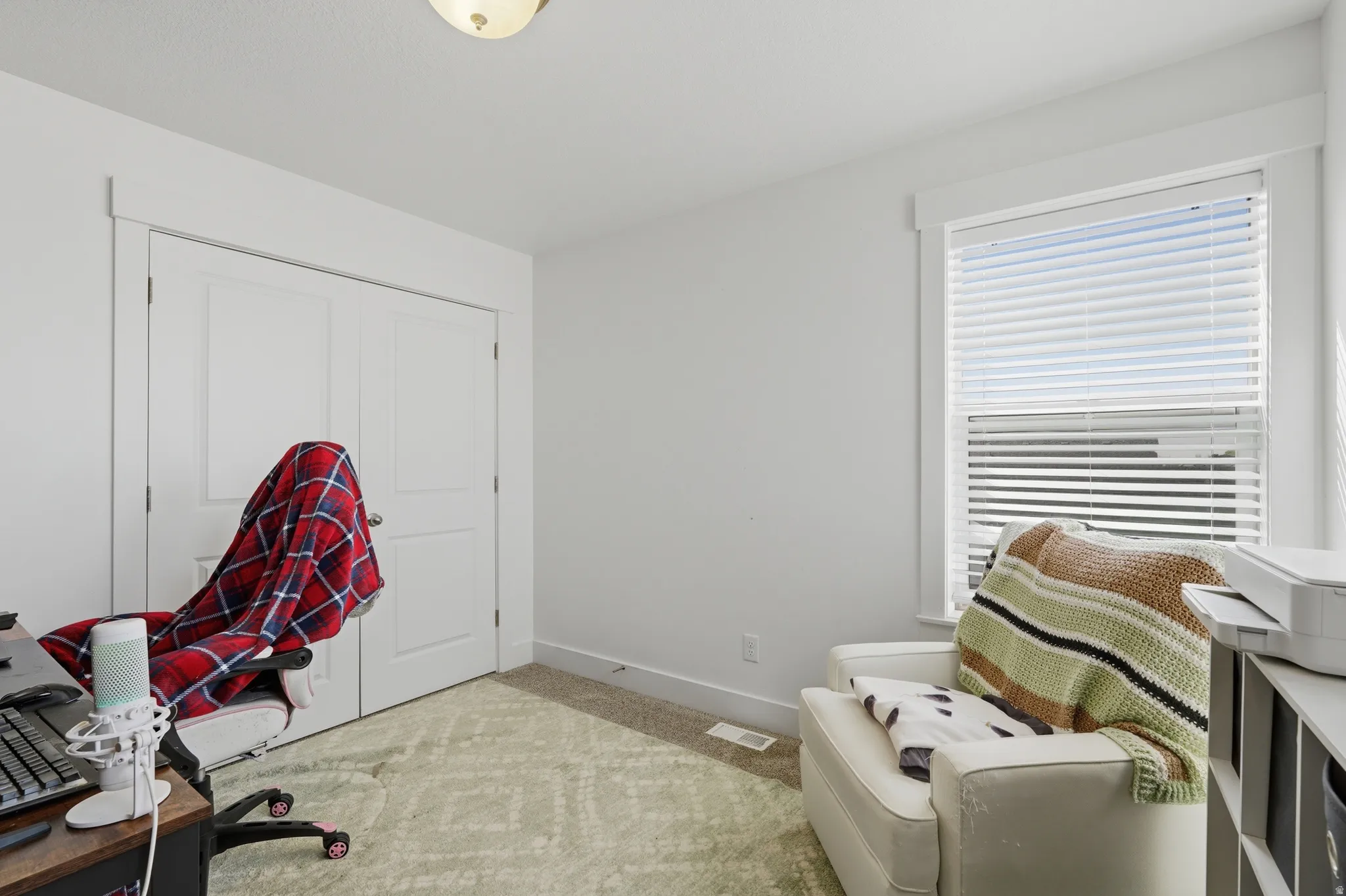 Office area featuring light carpet and baseboards