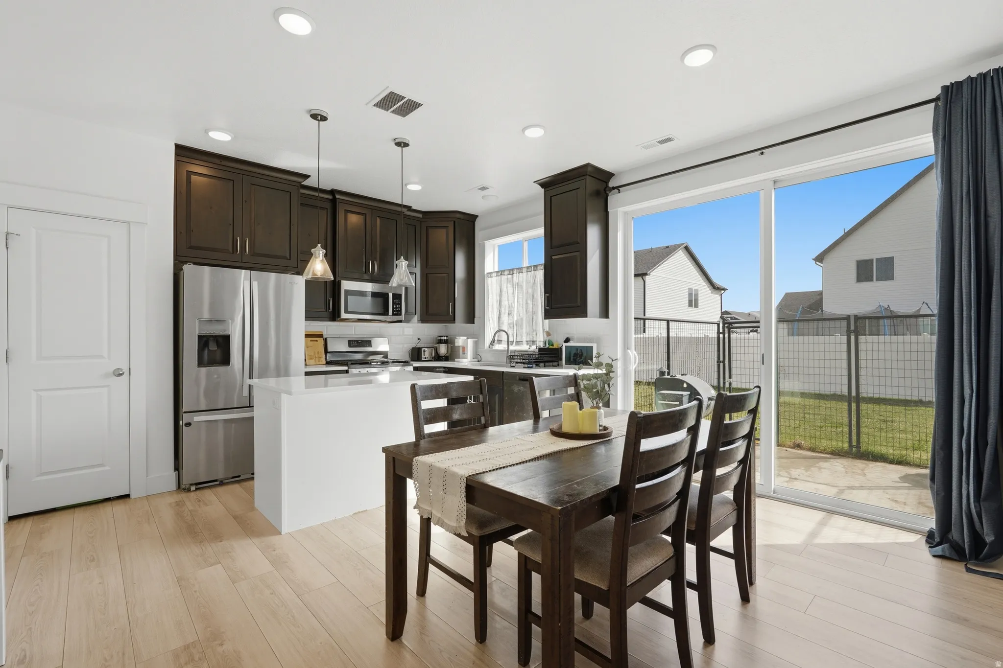 Dining space with light wood-type flooring and recessed lighting