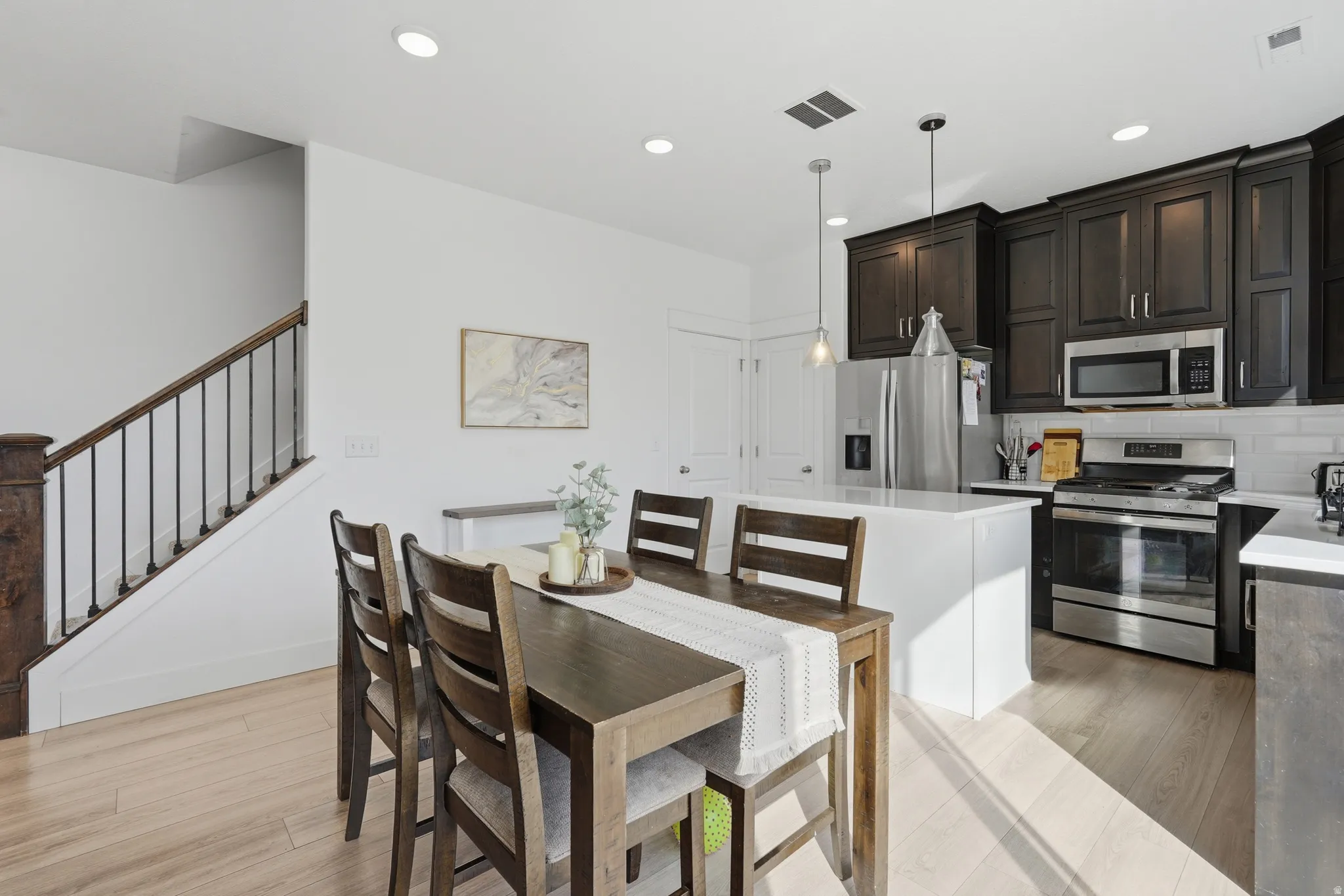 Dining space with light wood-style flooring and recessed lighting