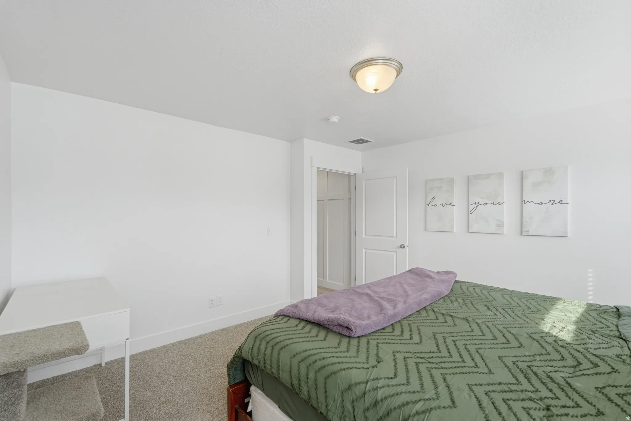 Bedroom with light colored carpet and baseboards