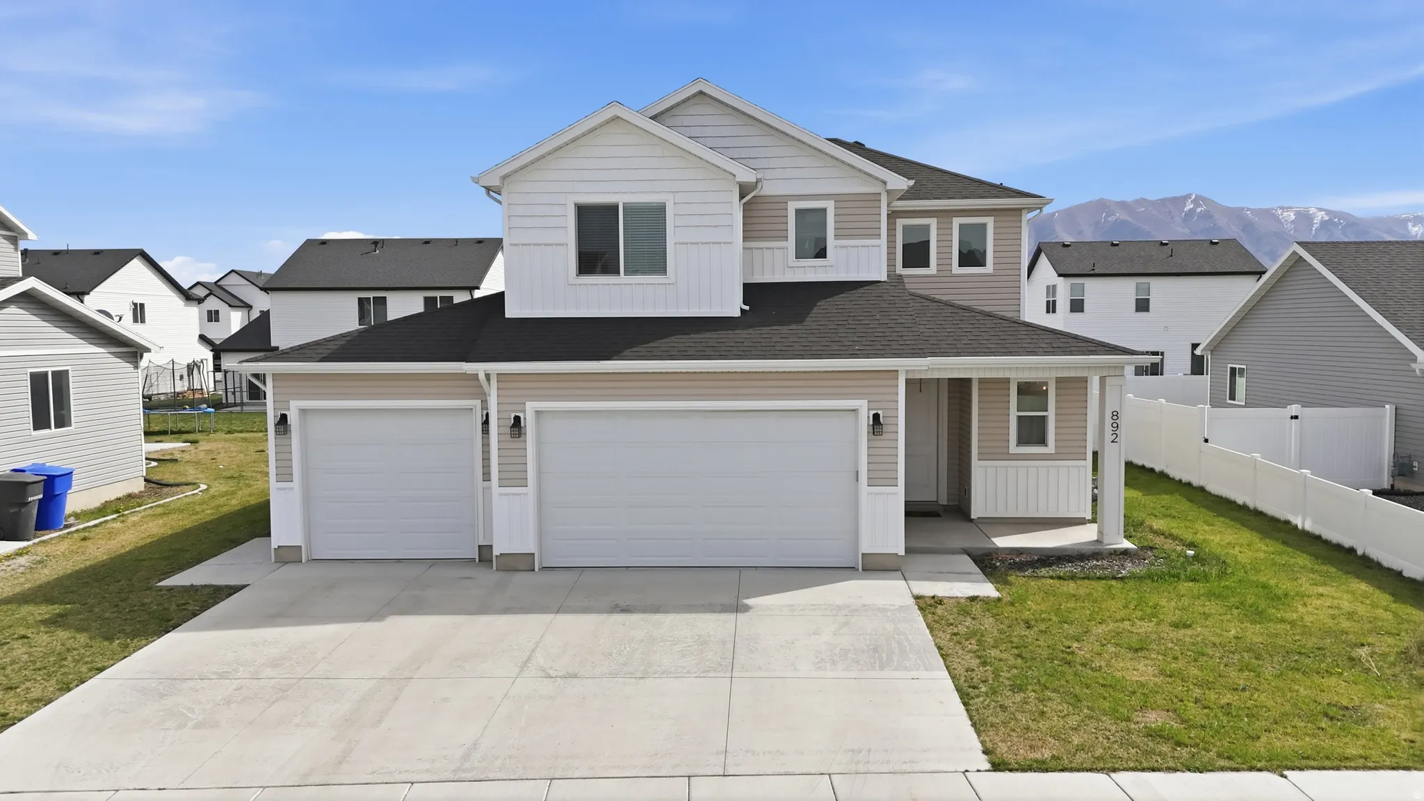 View of front of house with driveway, a residential view, board and batten siding, covered porch, and roof with shingles