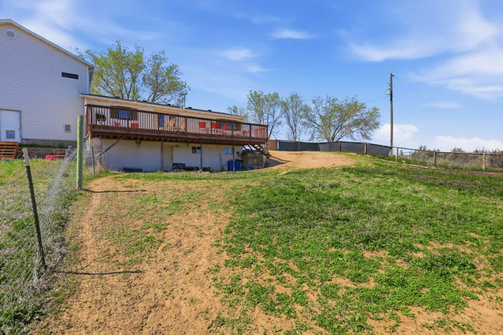 Rear view of house featuring a fenced backyard and a wooden deck