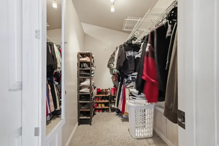 Walk in closet featuring light colored carpet