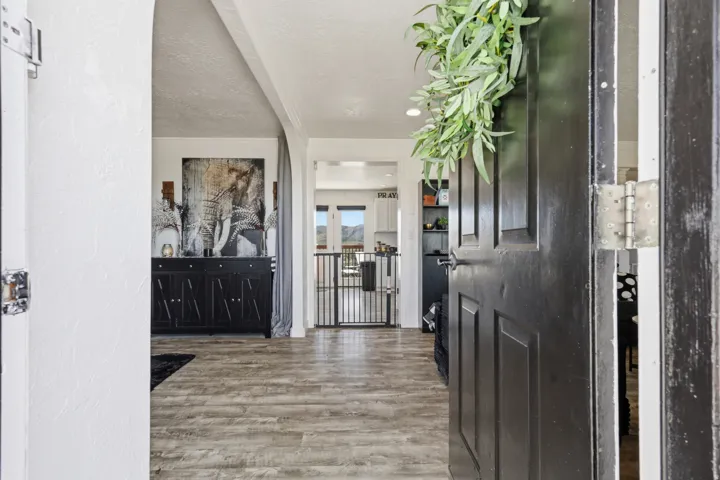 Entrance foyer with light wood-type flooring, a textured wall, a textured ceiling, and crown molding
