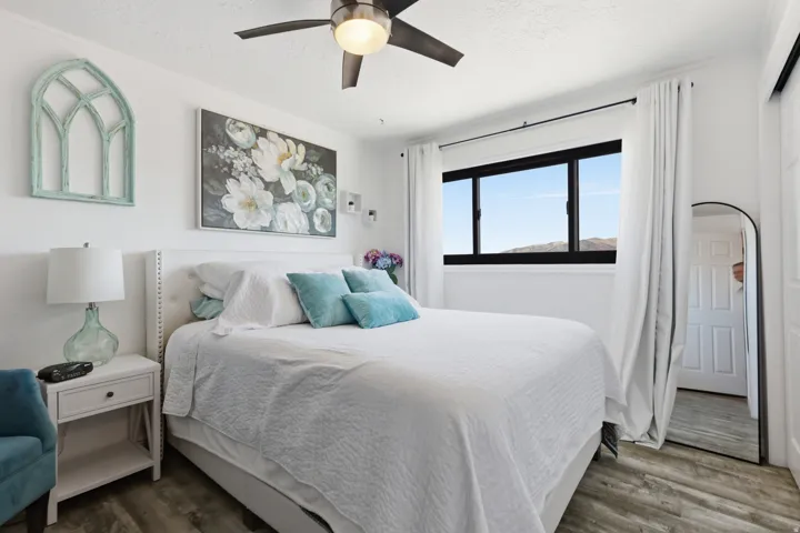 Bedroom with a textured ceiling, wood finished floors, and ceiling fan