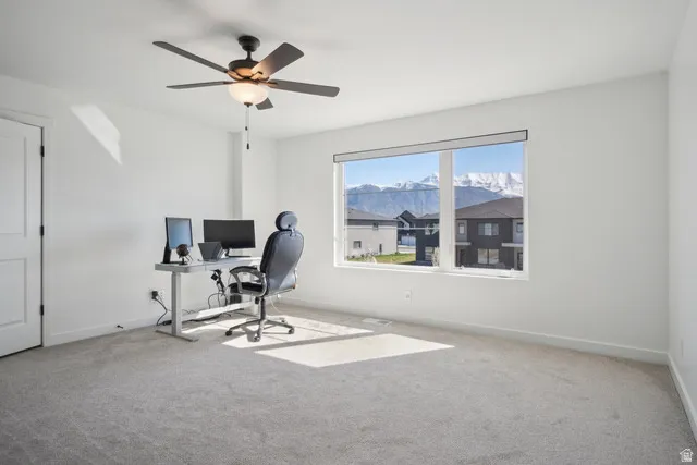 Home office with carpet floors and a ceiling fan
