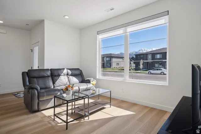 Living room with light wood-style floors and recessed lighting