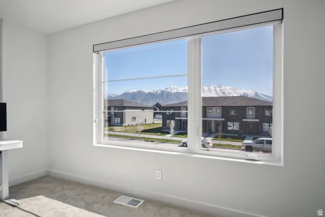 Empty room featuring carpet and a mountain view