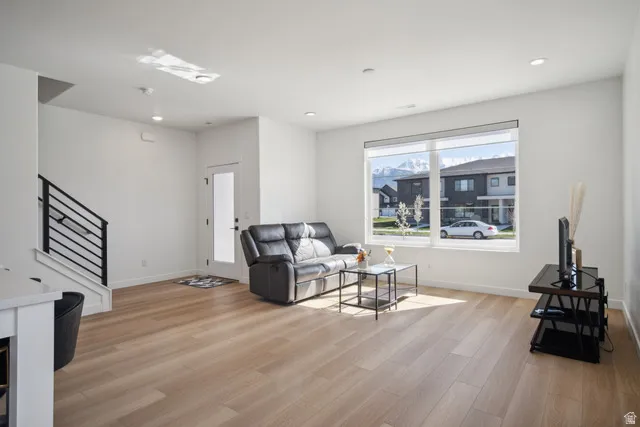 Living room with light wood finished floors and recessed lighting