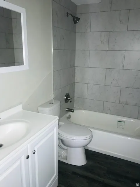Bathroom with vanity, dark wood-type flooring, and tub / shower combination