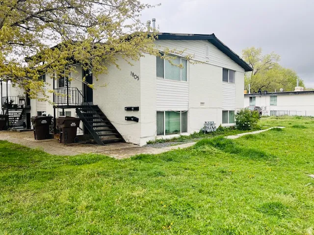 Rear view of property with a yard and brick siding