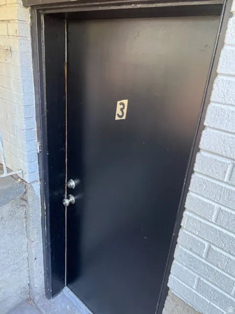 View of exterior entry with brick siding