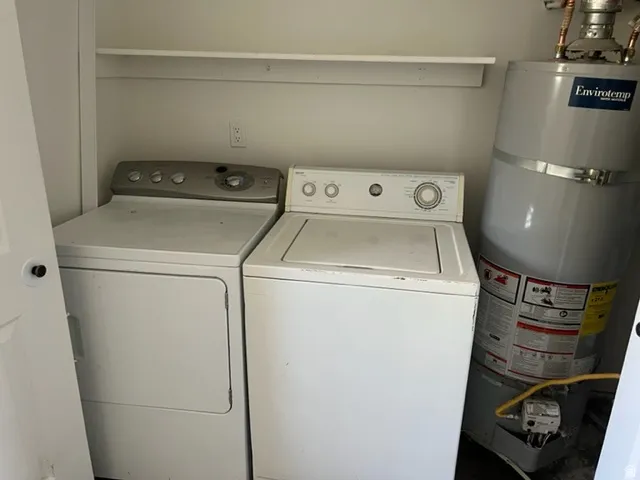 Laundry area featuring secured water heater and washer and dryer
