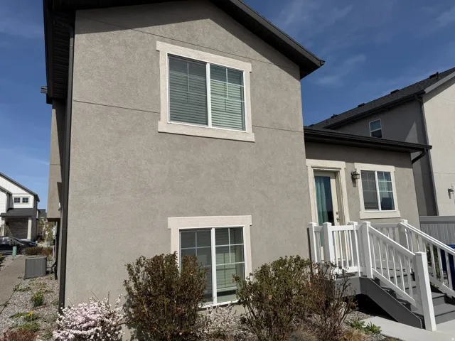 View of home's exterior with stucco siding and a central AC unit