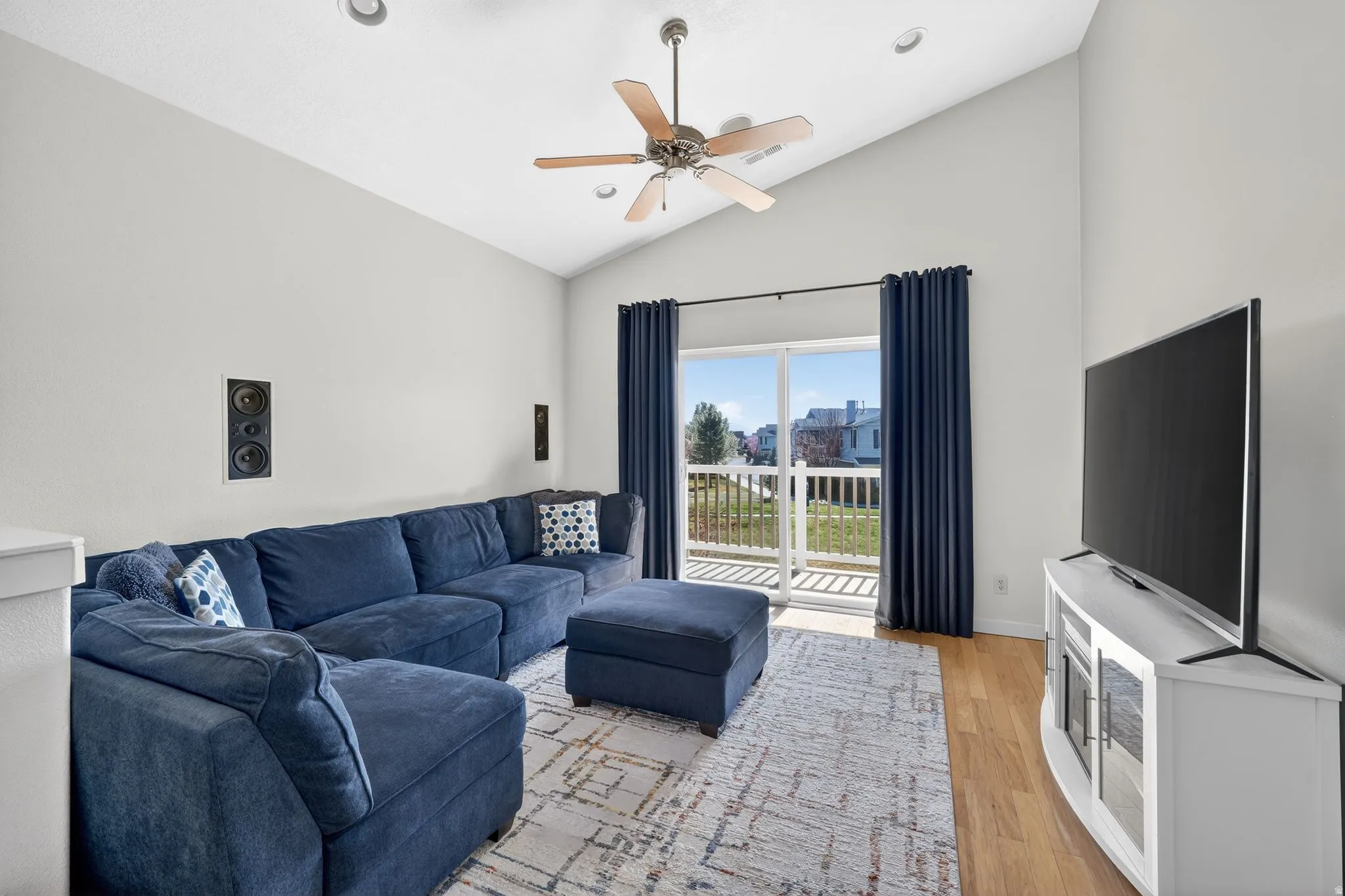 Living room with vaulted ceiling, light wood-style floors, ceiling fan, and recessed lighting