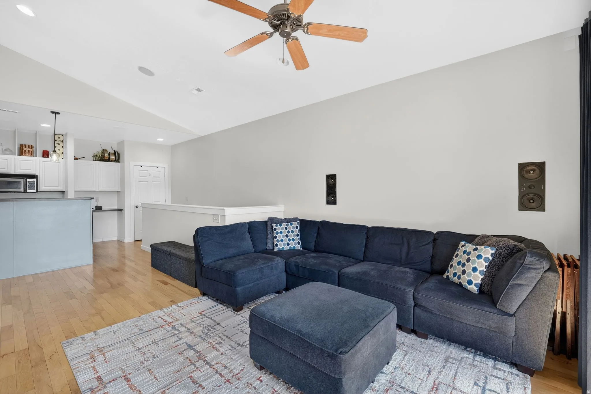 Living room featuring light wood-style flooring, a ceiling fan, lofted ceiling, and recessed lighting