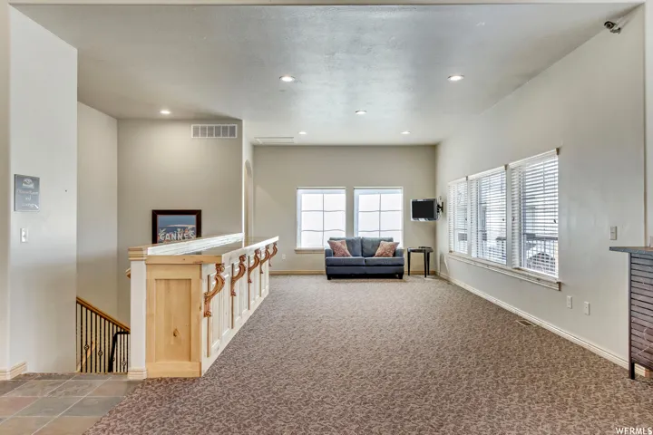 Carpeted living area featuring recessed lighting and baseboards