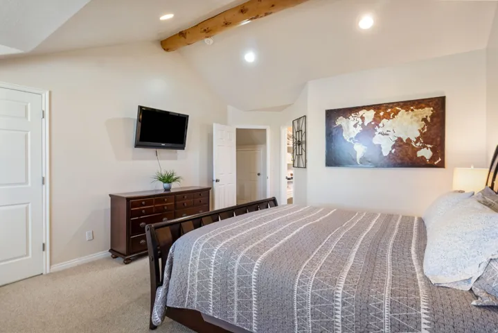 Bedroom featuring light carpet, recessed lighting, and beam ceiling