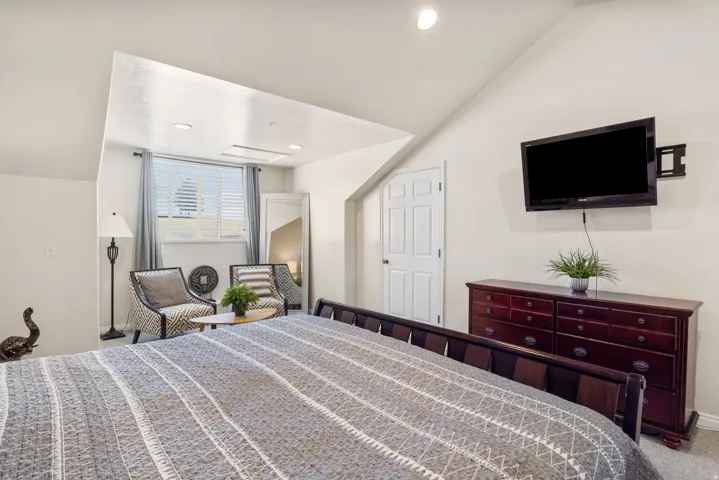 Bedroom with carpet flooring, vaulted ceiling, and recessed lighting