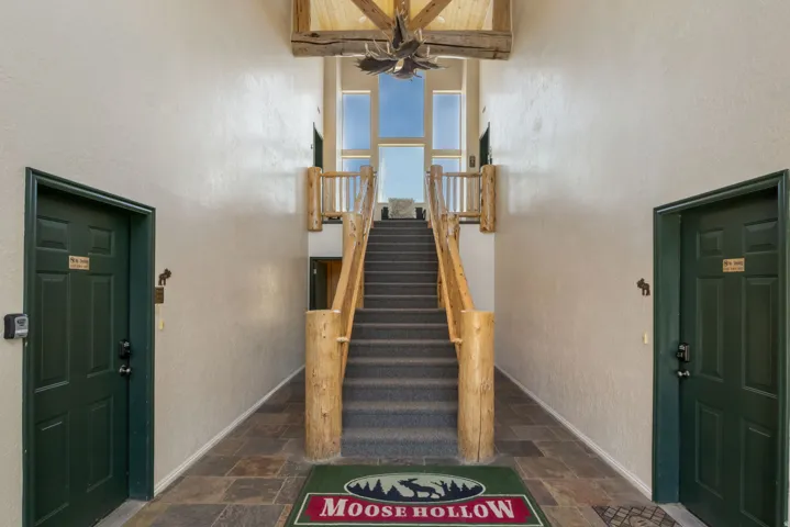 Staircase featuring stone finish flooring, a high ceiling, and a textured wall