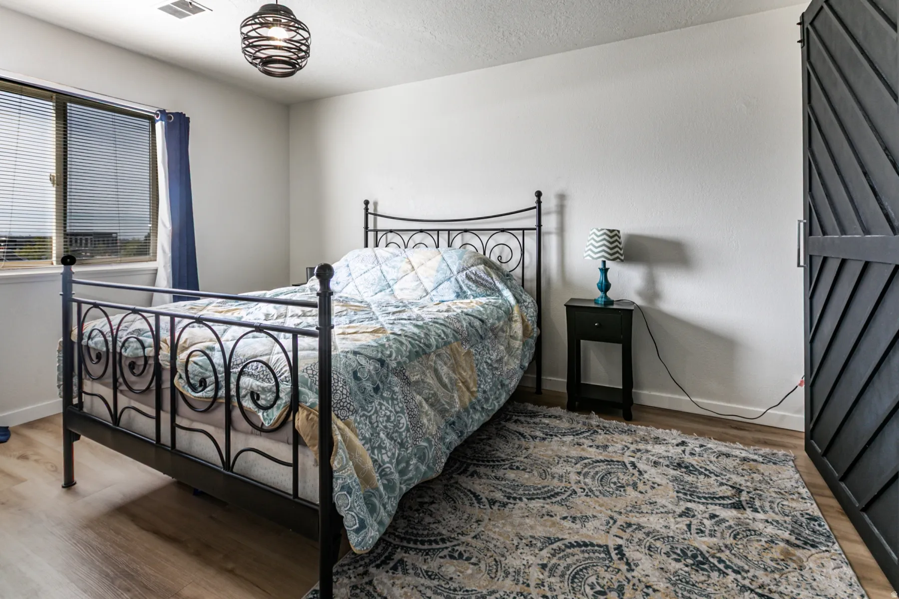 Bedroom with light wood-style floors and a textured ceiling