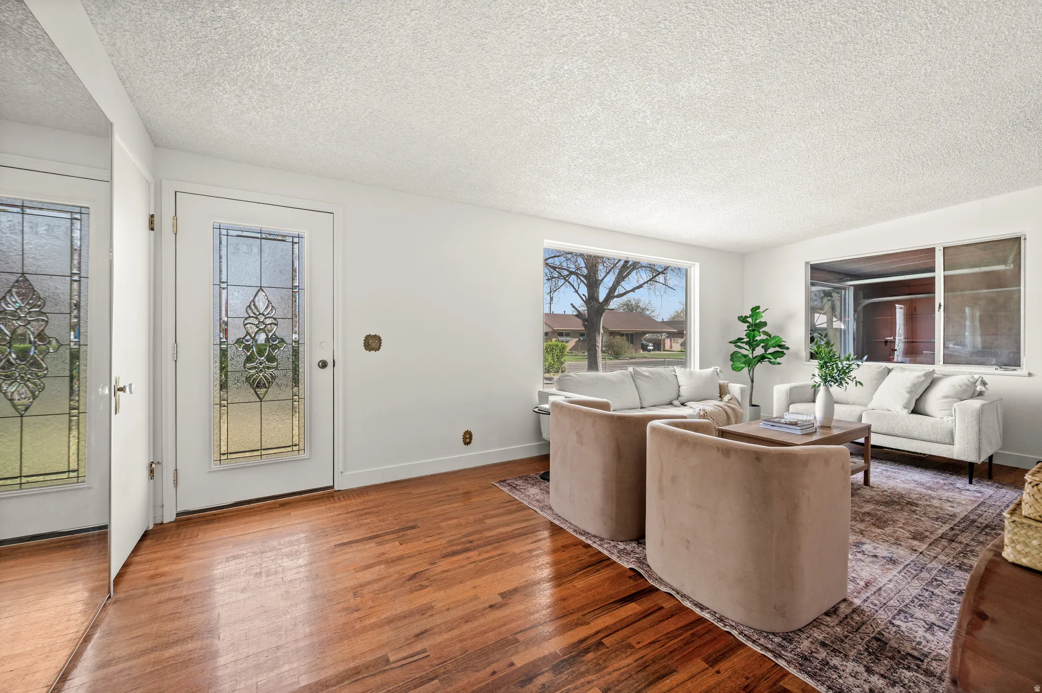 Living room with a textured ceiling and hardwood / wood-style flooring