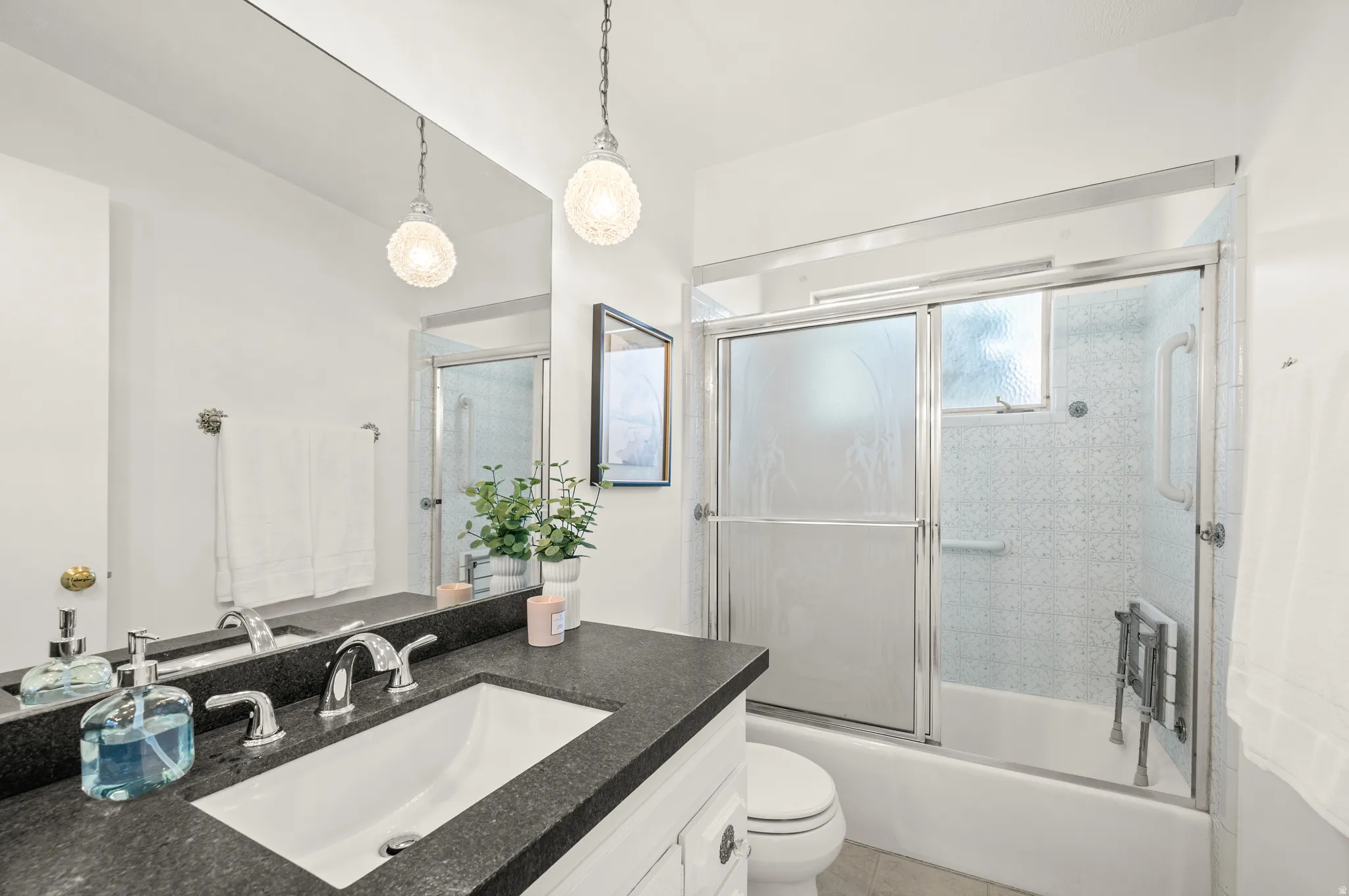Bathroom with vanity and bath / shower combo with glass door