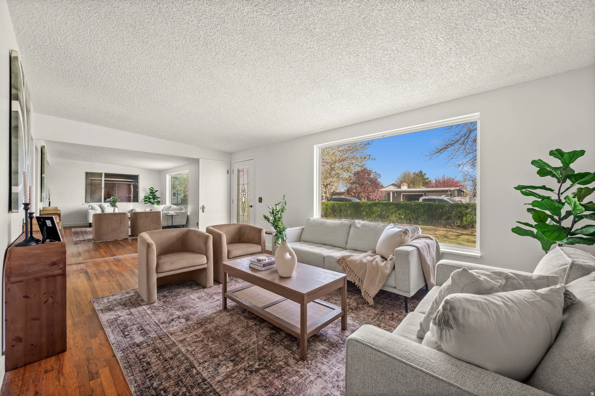 Living area with hardwood / wood-style floors and a textured ceiling