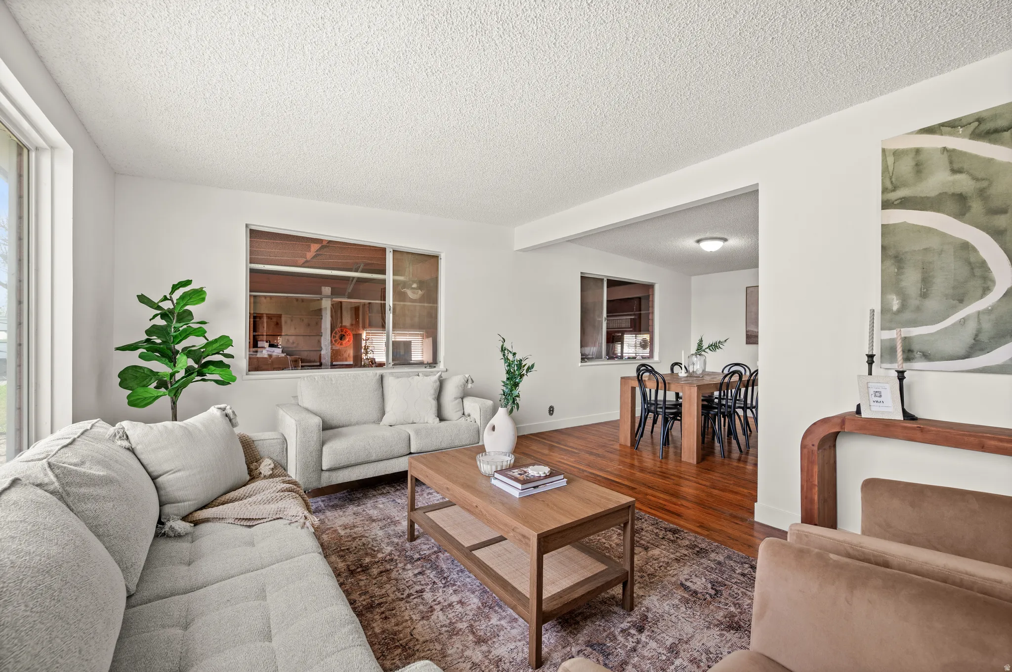 Living area with wood finished floors and a textured ceiling