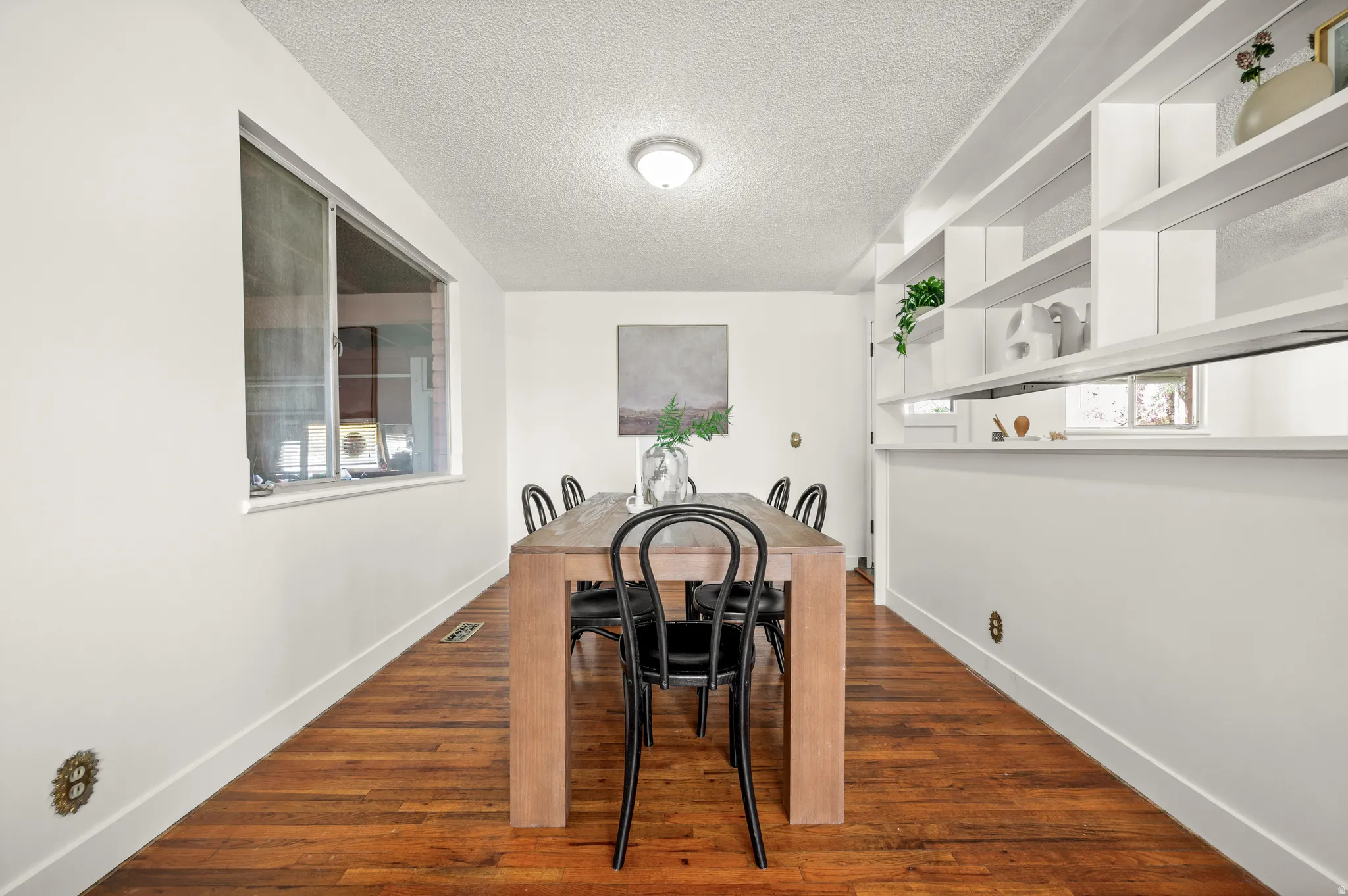 Dining room featuring dark wood-style flooring and a textured ceiling