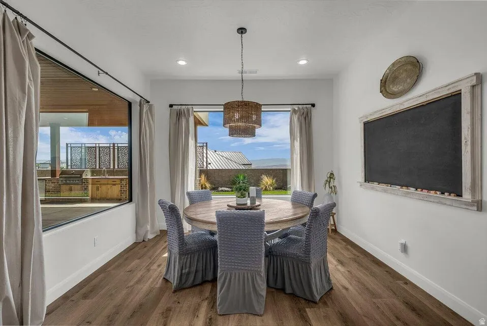 Dining area with dark wood-style flooring and recessed lighting