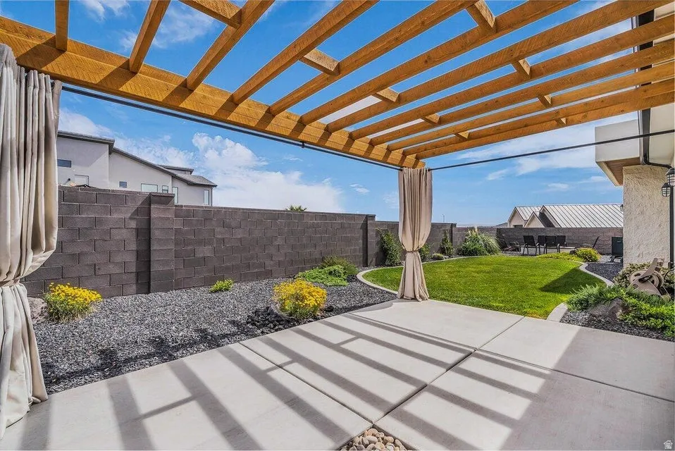 Fenced backyard featuring a pergola and a patio