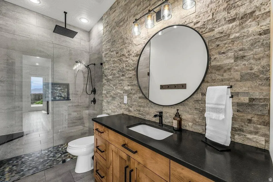 Full bathroom with vanity, a shower stall, recessed lighting, and dark tile patterned floors