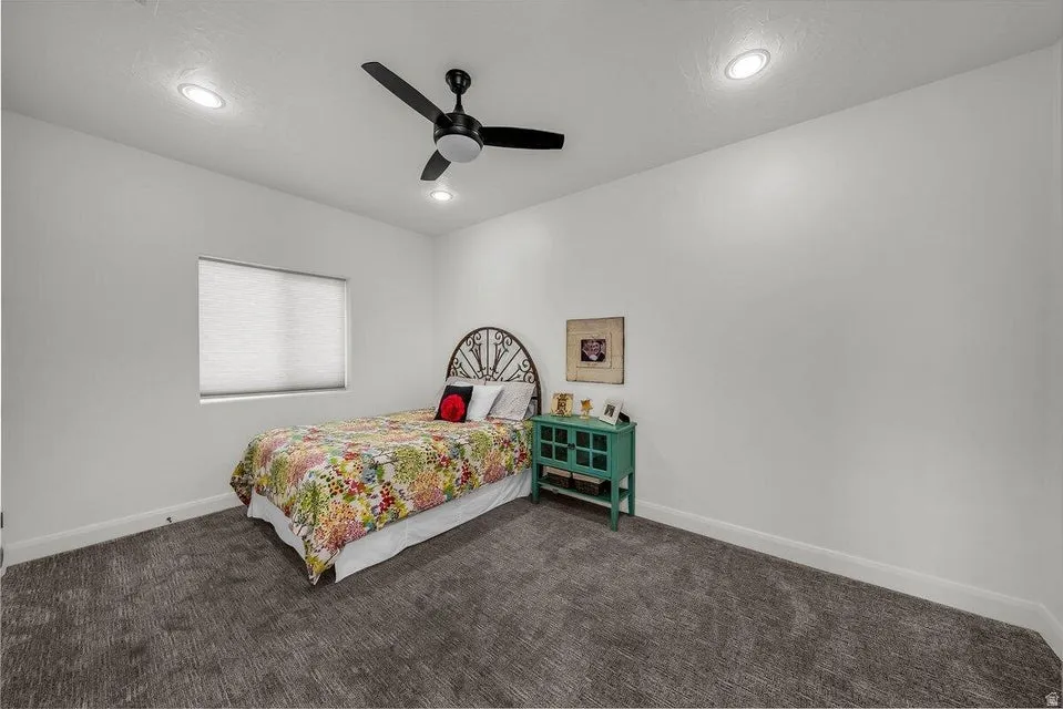 Bedroom featuring a ceiling fan, dark colored carpet, and recessed lighting