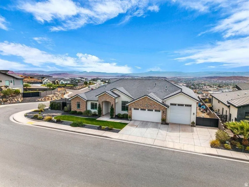 Ranch-style house featuring an attached garage, concrete driveway, a mountain view, and a residential view