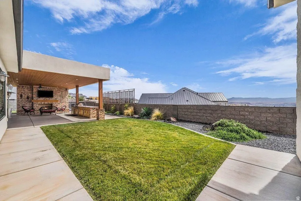 Fenced backyard featuring a patio area, an outdoor kitchen, and a mountain view