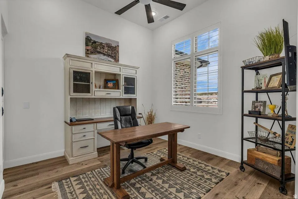 Office featuring a ceiling fan and dark wood-type flooring