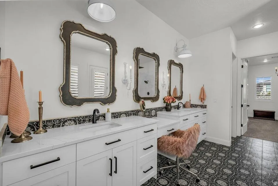 Full bathroom with double vanity and baseboards