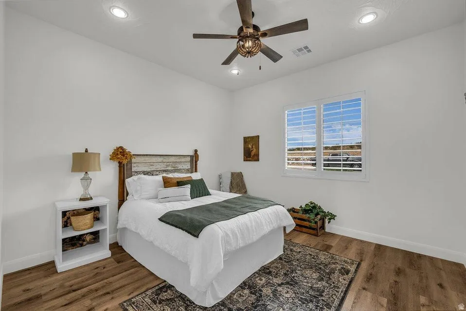 Bedroom with dark wood finished floors, ceiling fan, and recessed lighting