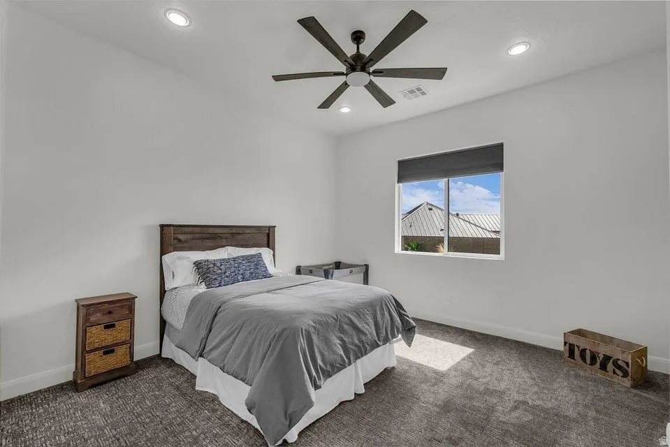 Bedroom with dark colored carpet, a ceiling fan, and recessed lighting