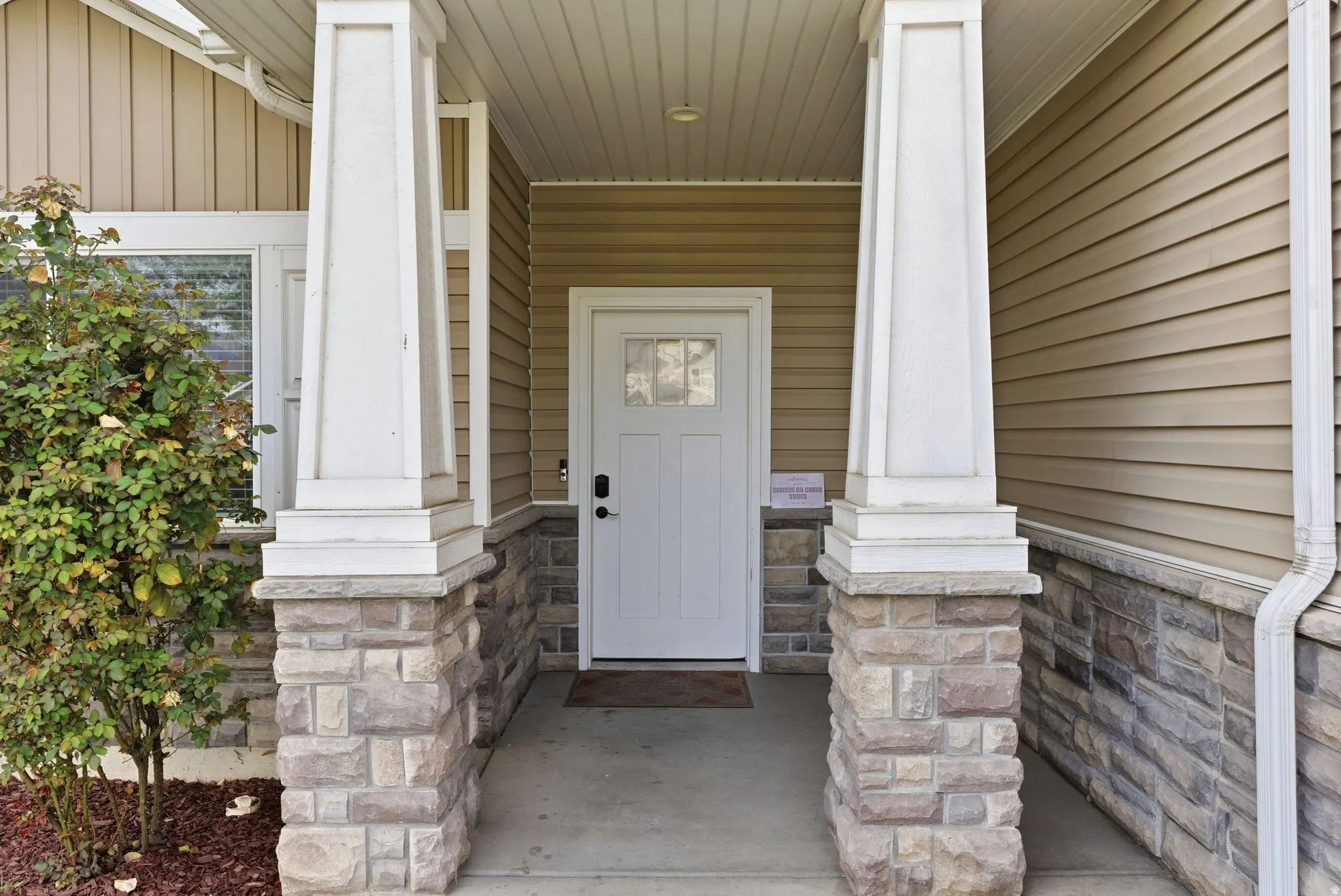 View of exterior entry featuring covered porch and board and batten siding