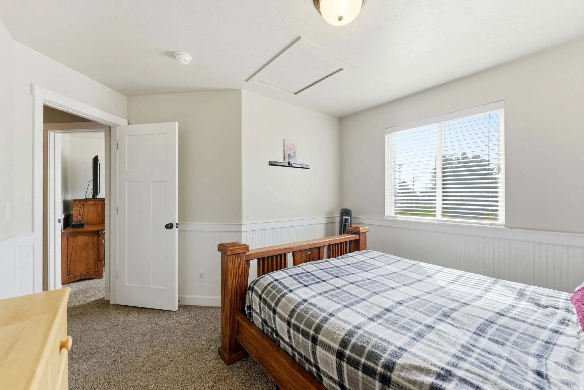 Bedroom with wainscoting and dark carpet