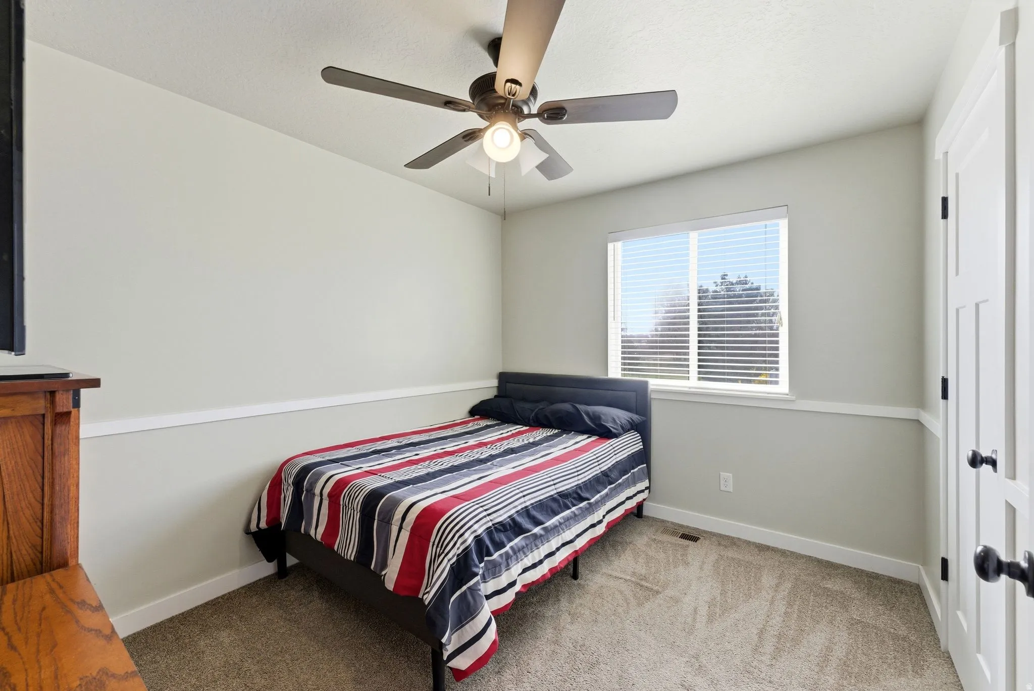 Bedroom with light colored carpet and ceiling fan