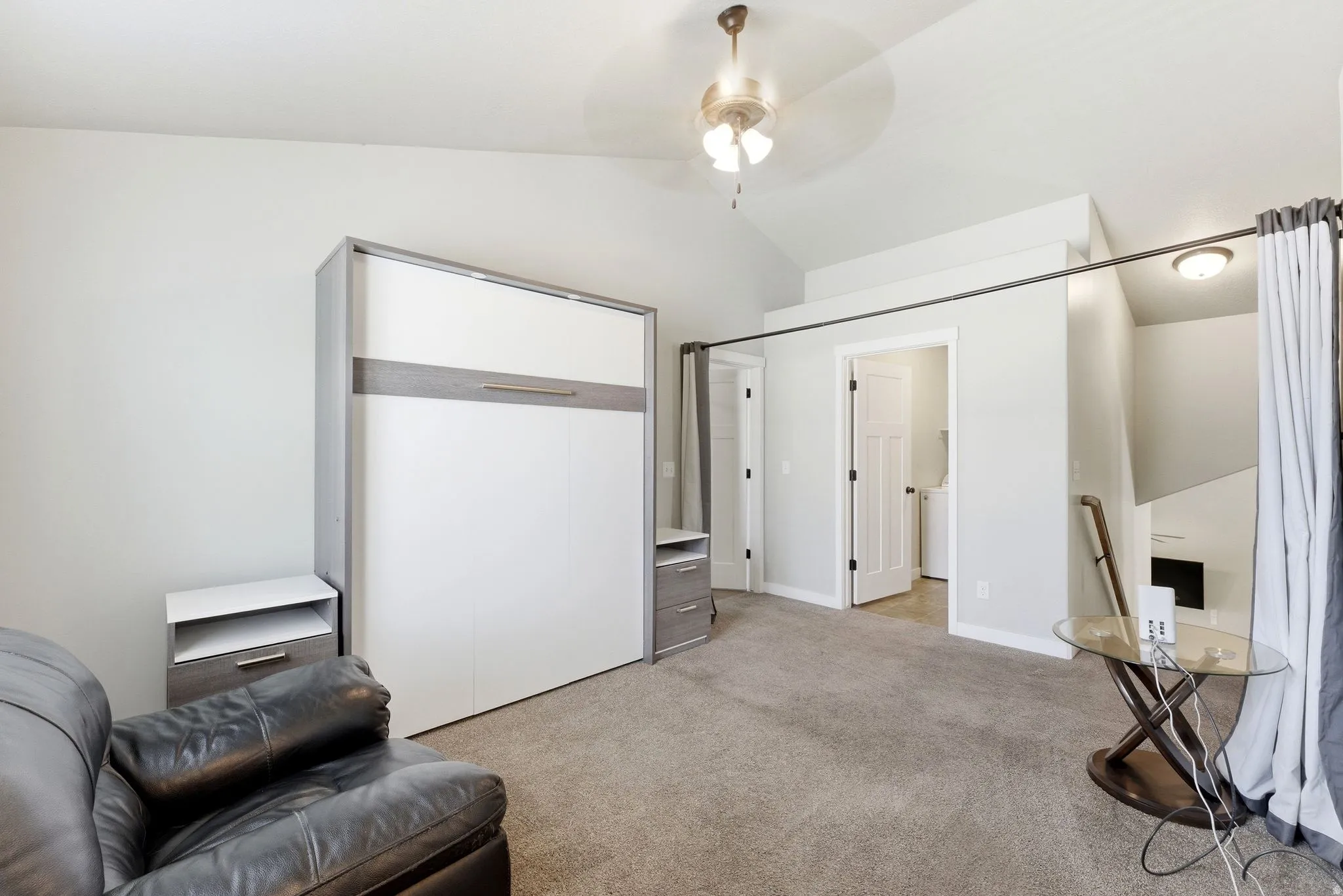 Living area with lofted ceiling, light carpet, and a ceiling fan