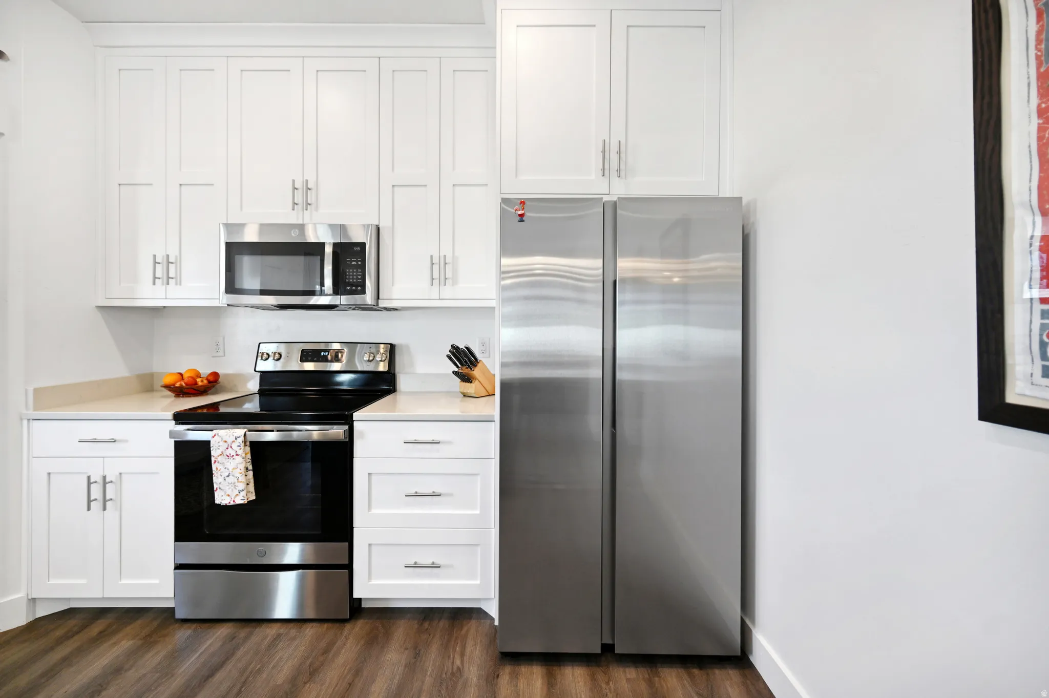 Kitchen featuring stainless steel appliances, white cabinetry, quartz countertops