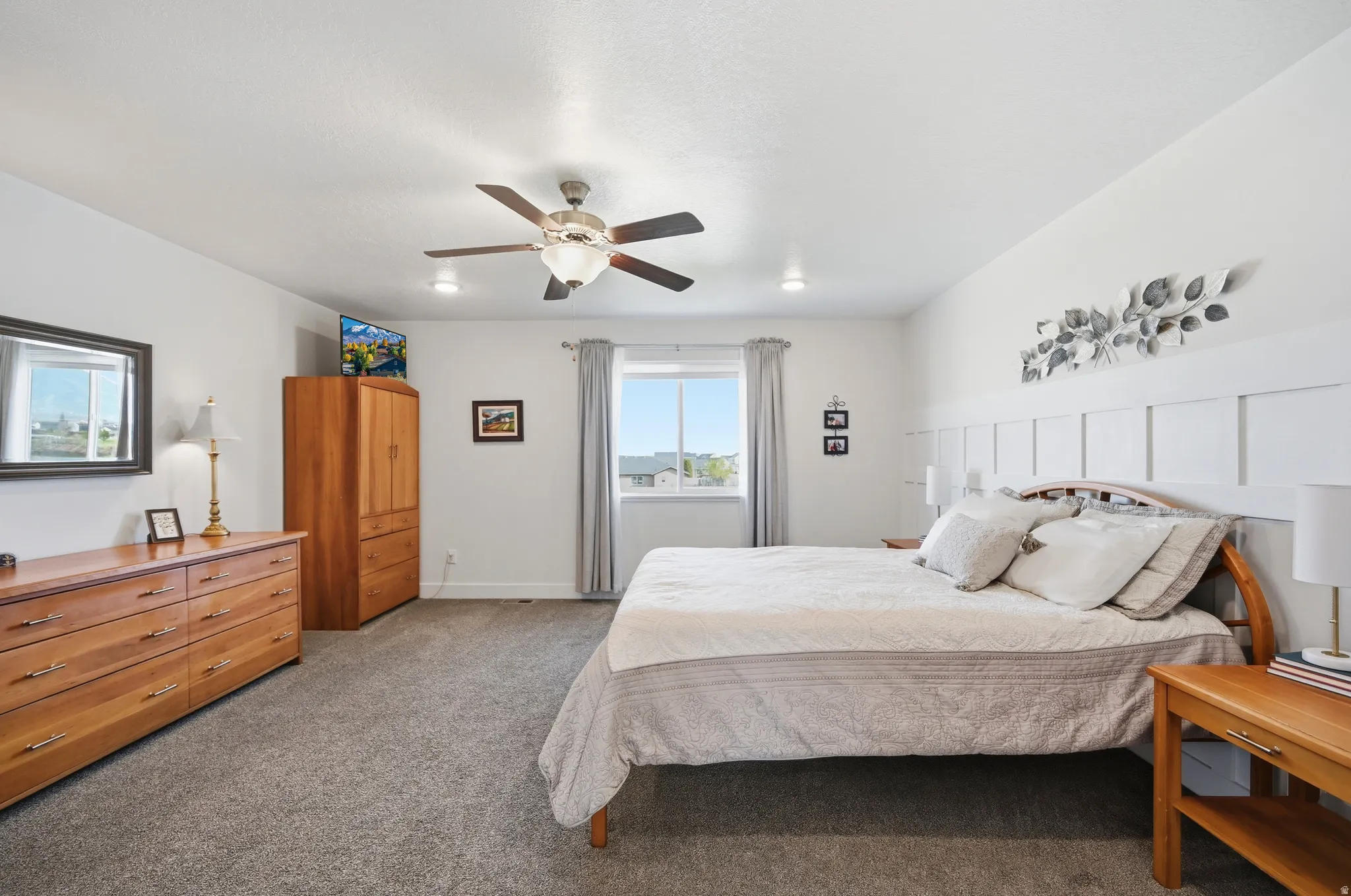 Owner's bedroom with carpet, ceiling fan and featuring a wainscoted wall