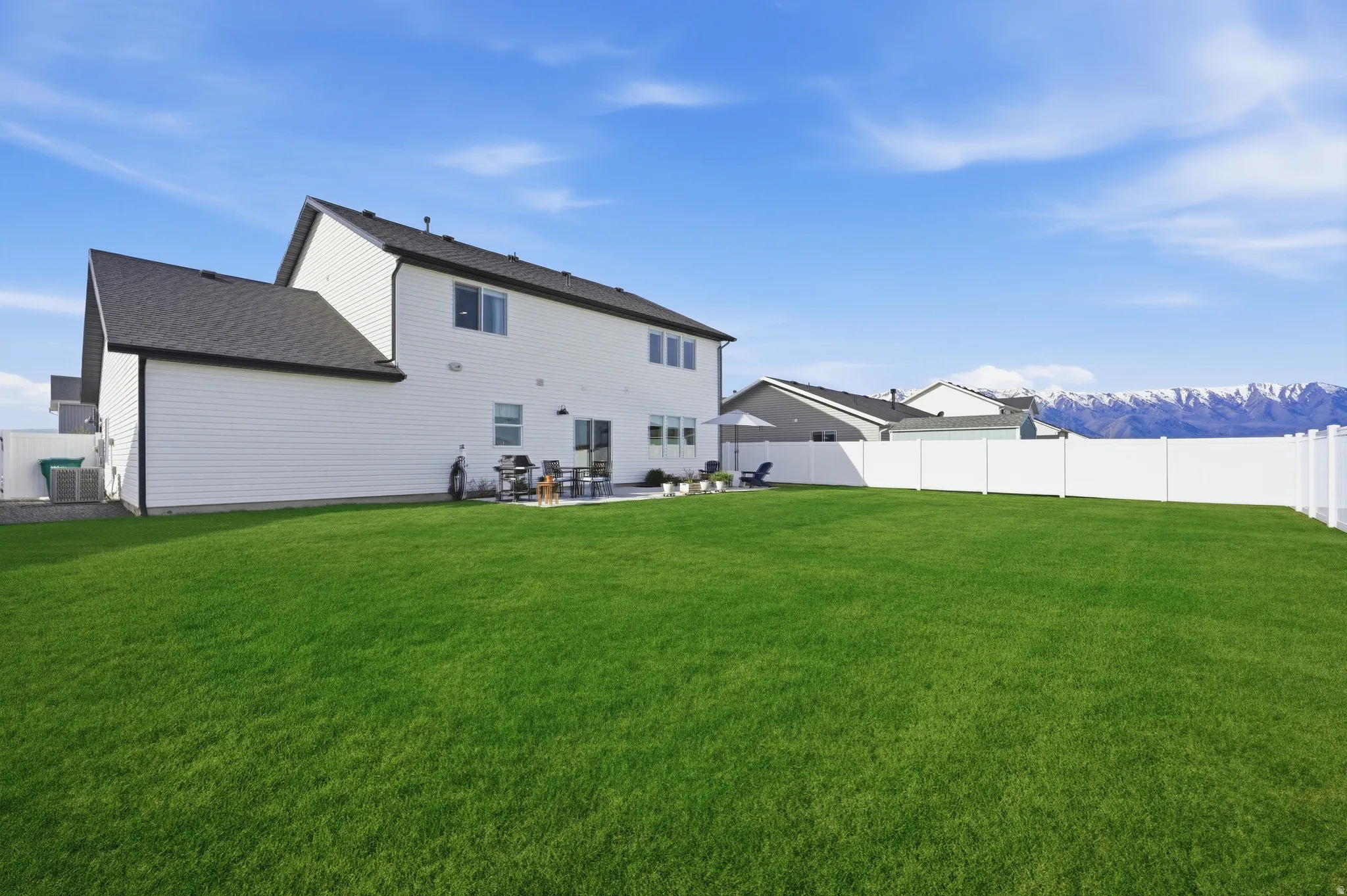 Back of property with a patio area, a shingled roof, a fenced backyard, and a mountain view