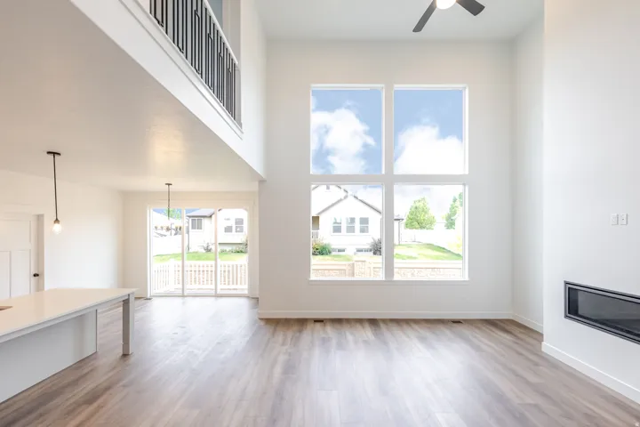 Two-story living area featuring tall windows and wood-finish flooring