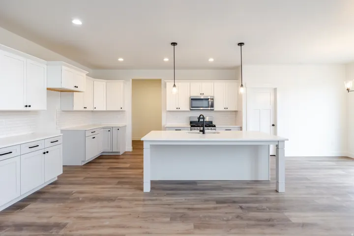 Modern kitchen featuring white cabinetry, subway tile backsplash, and wood-finish flooring